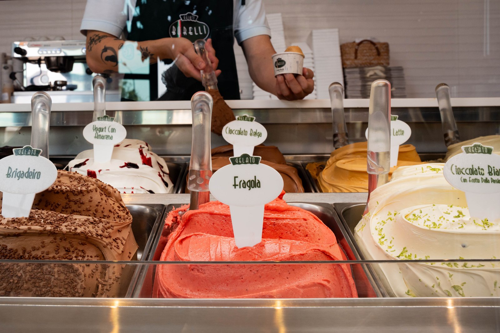Atendente Borelli servindo gelato na vitrine da loja